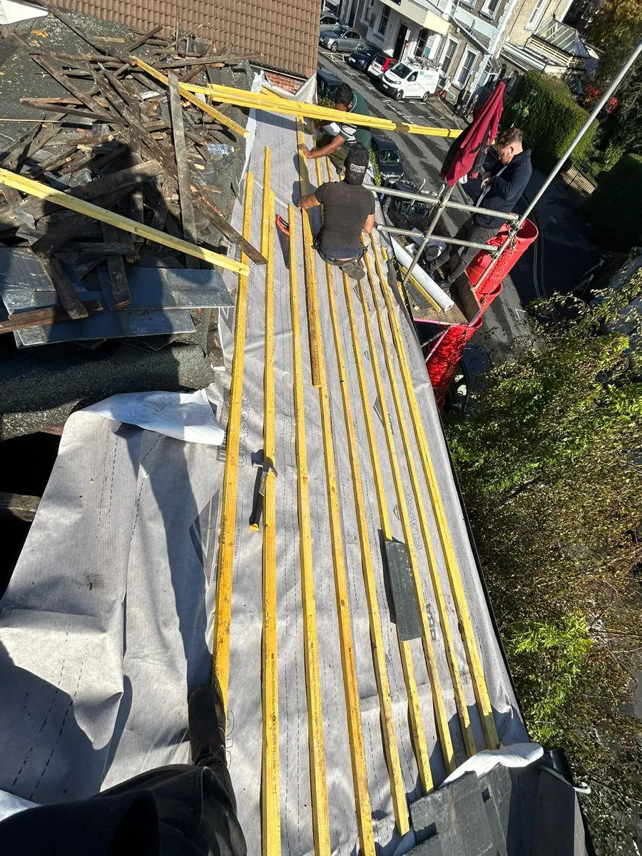 Team setting out battens over new membrane on a pitched roof, Imperial Roofcraft roofing job in London