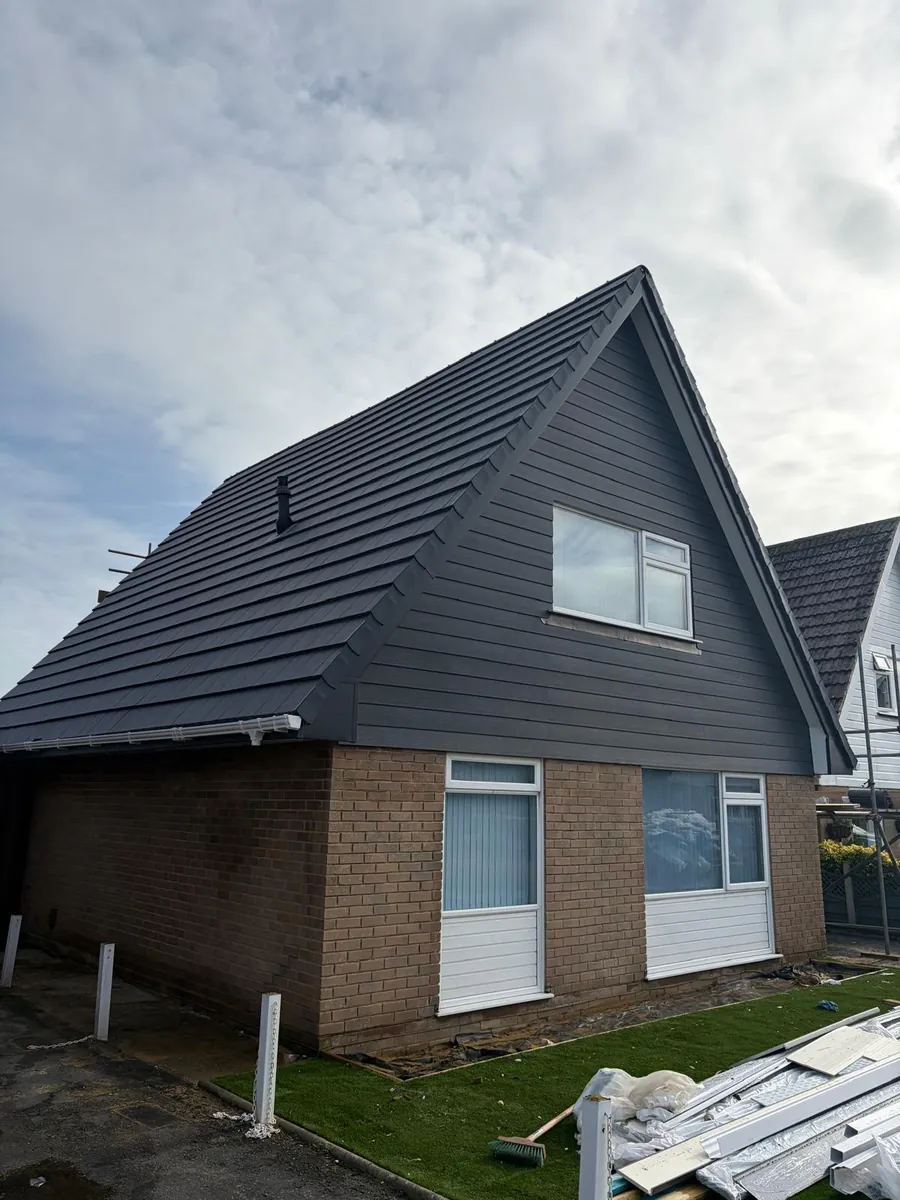 Finished grey tiled roof and grey cladding on a chalet bungalow, Imperial Roofcraft roofing job in London and Surrey