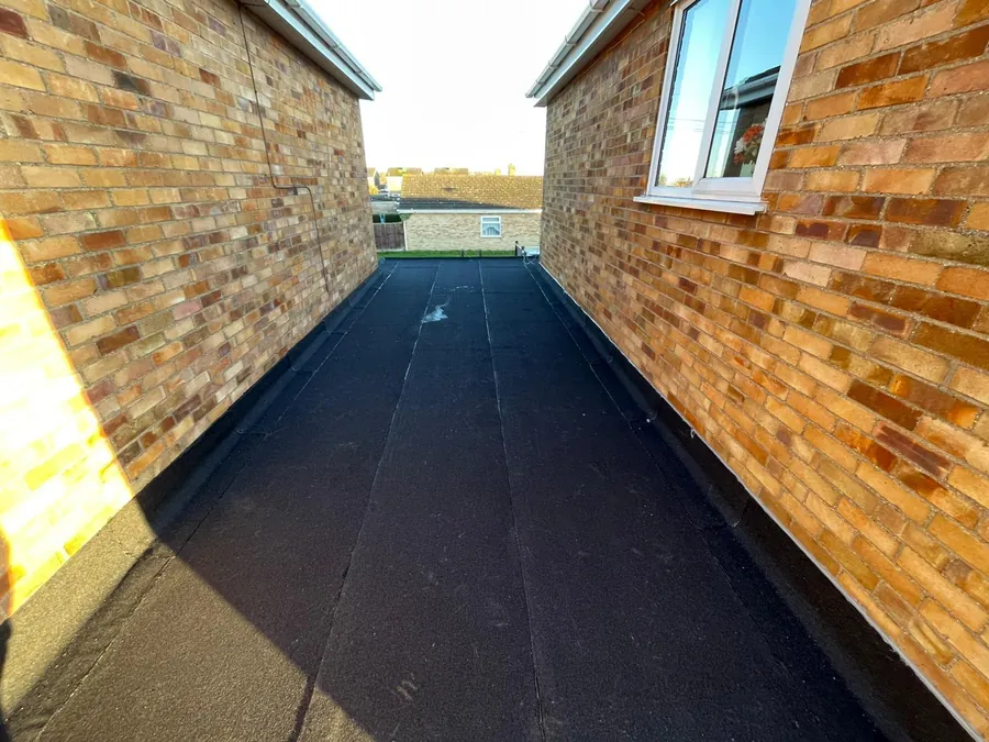 Felt flat roof finished between two brick walls, Imperial Roofcraft roofing job in London and Surrey
