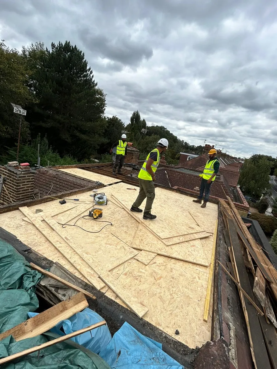 Roofers measuring out a new flat roof deck, Imperial Roofcraft roofing job in London