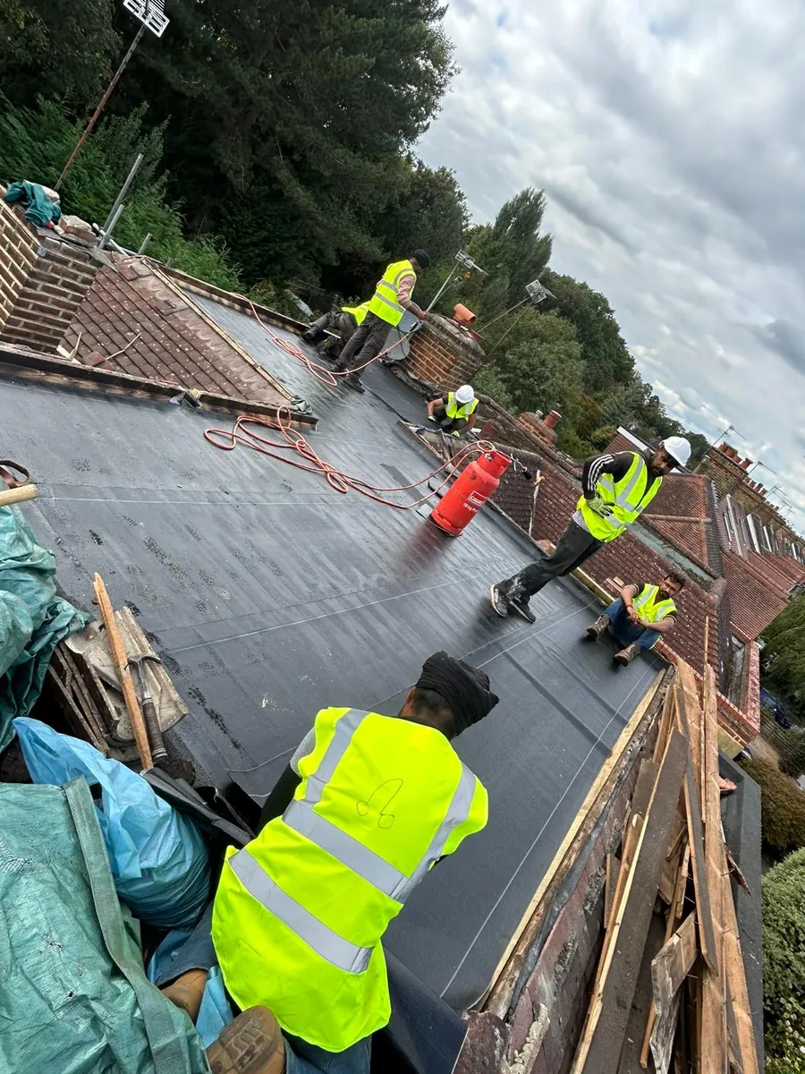 Imperial Roofcraft team in hi-vis laying a flat roof covering, Imperial Roofcraft roofing job in London