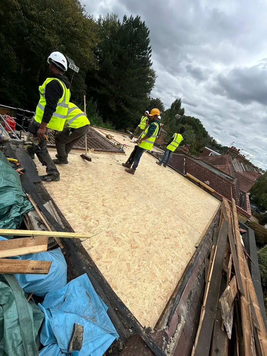 Team boarding a flat roof with OSB sheets, Imperial Roofcraft roofing job in London