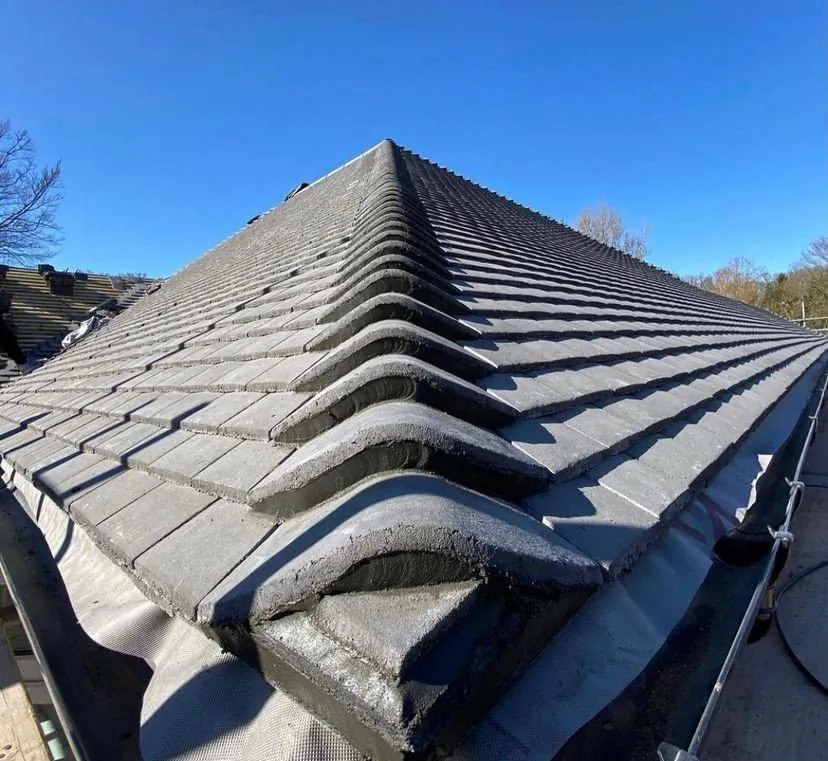 Grey interlocking tile hip finished with ridge caps, Imperial Roofcraft roofing job in London