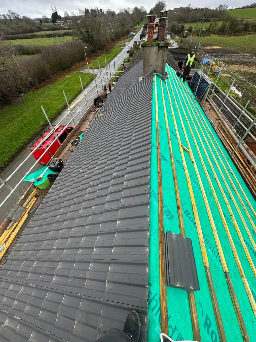Grey tiles half laid over green breathable membrane, Imperial Roofcraft roofing job in London and Surrey