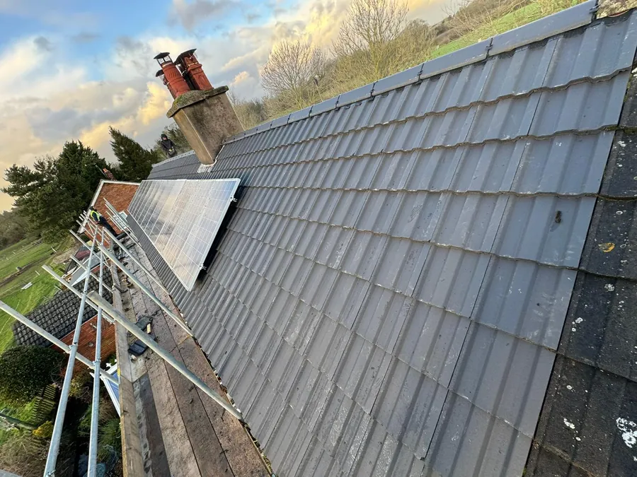 Completed grey tiled roof with a chimney and solar panels, Imperial Roofcraft roofing job in London and Surrey