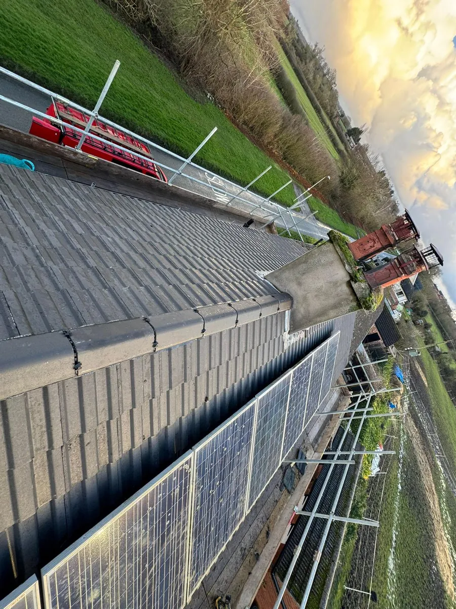 Grey tiles finished below solar panels, seen from the scaffold, Imperial Roofcraft roofing job in London and Surrey