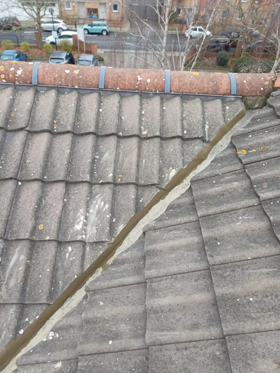 Weathered grey concrete tiles meeting at a valley, Imperial Roofcraft roofing job in London and Surrey