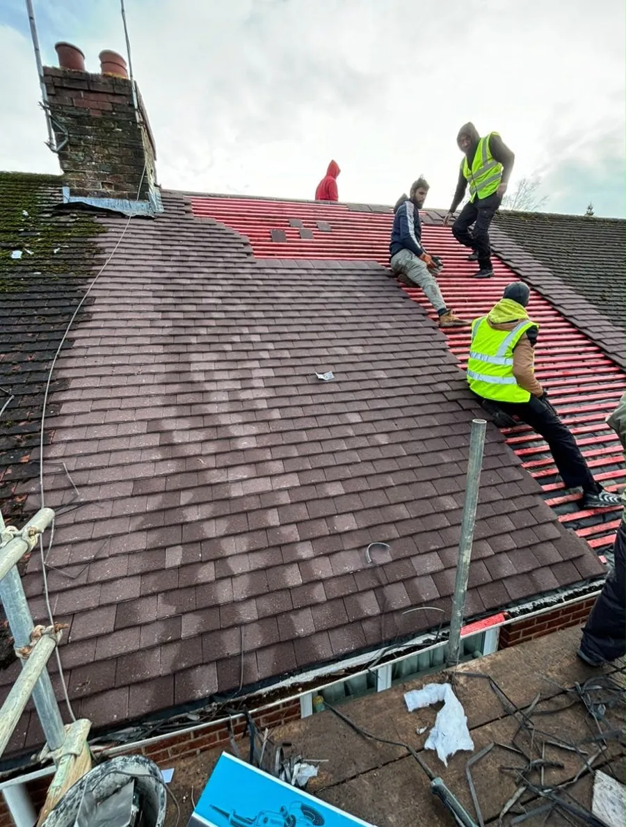 Team in hi-vis stripping and re-tiling a red tile roof, Imperial Roofcraft roofing job in London and Surrey