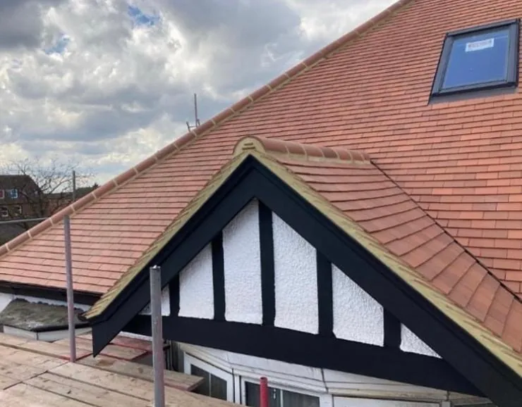 Red clay tiled roof above a black and white timbered gable, Imperial Roofcraft roofing job in London