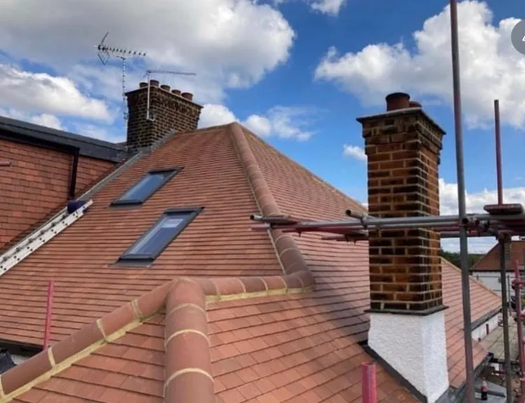Red clay tile hip roof with a rooflight and chimney, Imperial Roofcraft roofing job in London