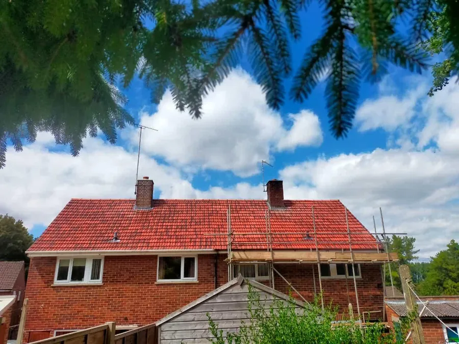Red tiled house roof with scaffold up for the work, Imperial Roofcraft roofing job in London