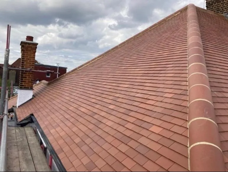 Red plain tile roof with a new ridge and brick chimney, Imperial Roofcraft roofing job in London