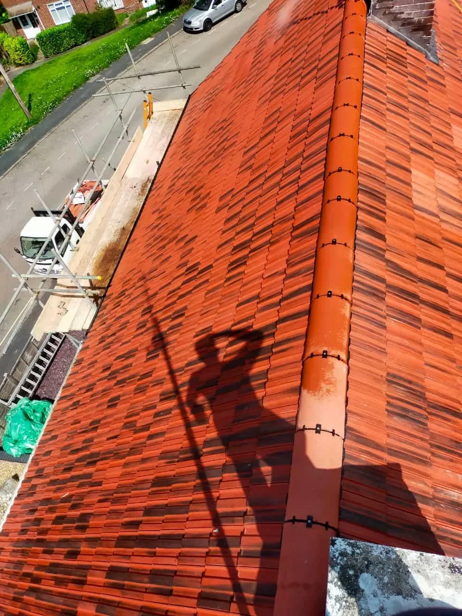 Fresh red tile courses above the scaffold boards, Imperial Roofcraft roofing job in London