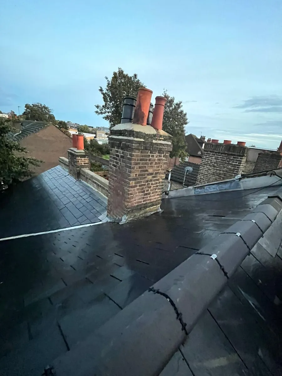 Slate roof around a brick chimney stack with clay pots, Imperial Roofcraft roofing job in London