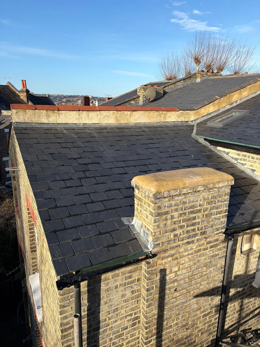 Slate roof around a yellow stock brick chimney stack, Imperial Roofcraft roofing job in London and Surrey