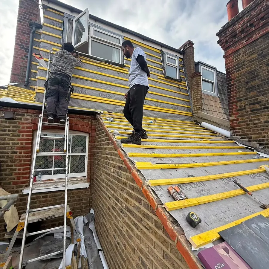 Two roofers battening a terrace roof beside a dormer, Imperial Roofcraft roofing job in London