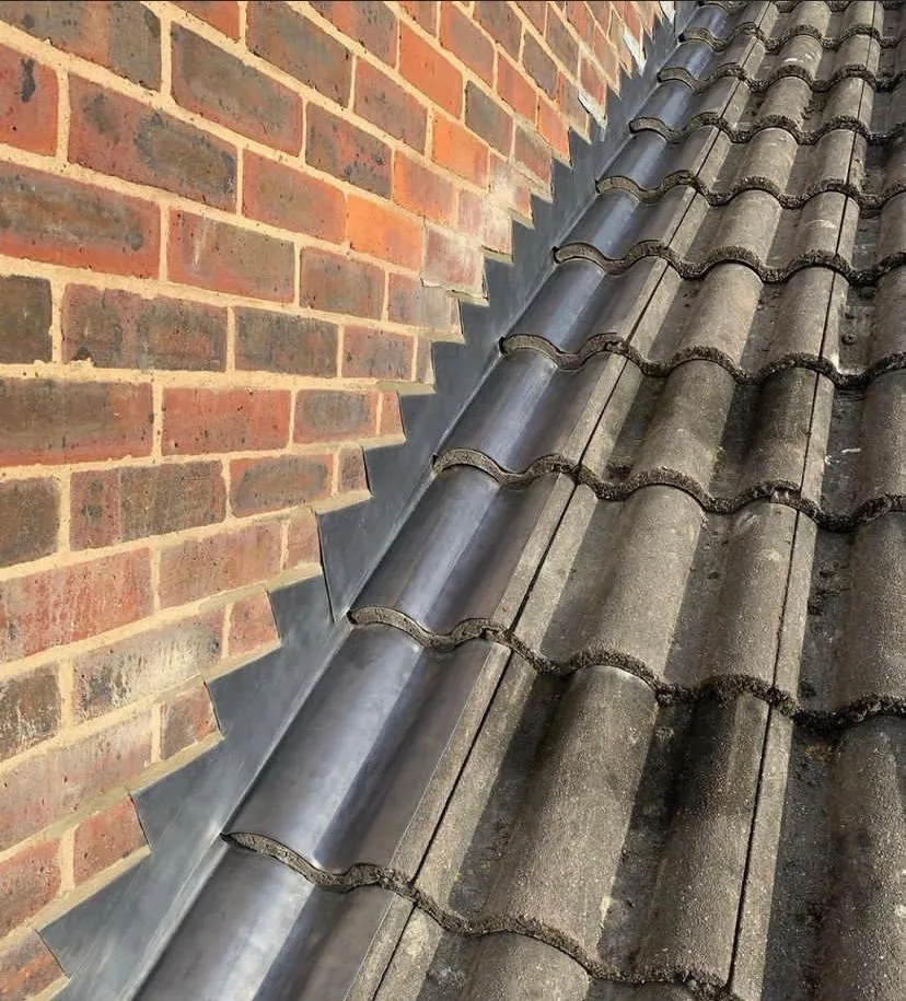 Concrete tiles finished against a brick wall abutment, Imperial Roofcraft roofing job in London